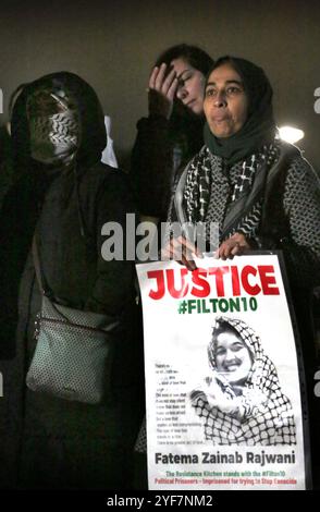 Reigate, Angleterre, Royaume-Uni. 2 novembre 2024. La mère de Fatima Zainab Rajwani tient une pancarte avec l'image de sa fille soutenue par des amis pendant la manifestation. Amis et famille se réunissent devant le HMP Bronzefield dans le Surrey pour faire du bruit et offrir leur soutien à six activistes de Palestine action qui sont en détention provisoire. Les six Fatema Rajwani, Zoe Rogers, Charlotte Head, Hannah Davidson, Leona Kamio et Madeleine Norman ont été arrêtées en vertu de la loi sur le terrorisme après avoir écrasé les installations d'Elbit Systems et paralysé l'usine. (Crédit image : © Martin Pope/ZUMA Banque D'Images