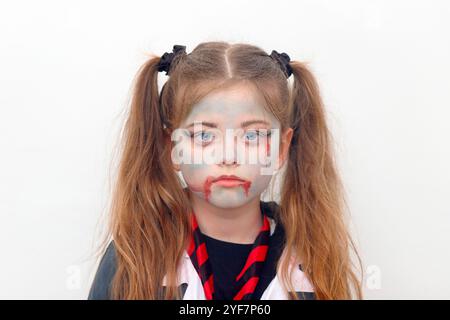 Une fille de 9 ans avec zombie se maquille pour Halloween Banque D'Images