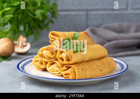 Crêpes ou crêpes fines farcies de poulet et de champignons dans une assiette Banque D'Images