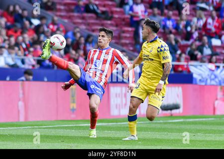 Madrid, Espagne. 3 novembre 2024. Giuliano Simeone (G) de l'Atletico de Madrid rivalise avec Alberto Moleiro de UD Las Palmas lors du match de football de la Liga entre l'Atletico de Madrid et UD Las Palmas à Madrid, Espagne, le 3 novembre 2024. Crédit : Gustavo Valiente/Xinhua/Alamy Live News Banque D'Images