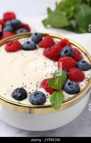 Savoureux porridge de semoule cuit avec des baies et de la menthe sur la table, gros plan Banque D'Images