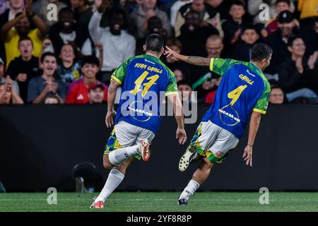 Tim Cahill et son fils Kyah Cahill du XI de Cahill célèbrent le but de Tim lors du match d'exposition Joga Bonito Tour entre le XI de Ronaldinho et le XI de Cahill au CommBank Stadium de Sydney. Le Joga Bonito Tour est un match de football organisé au CommBank Stadium de Sydney le 1er novembre 2024. Le match a été joué entre le XI de Ronaldinho et le XI de Cahill, menés respectivement par l'ancien footballeur brésilien Ronaldinho et l'ancien footballeur australien Tim Cahill. Les deux équipes étaient composées de plusieurs anciens footballeurs notables tels que Brett Emerton, Kevin-Prince Boateng, Aaron Mooy Banque D'Images