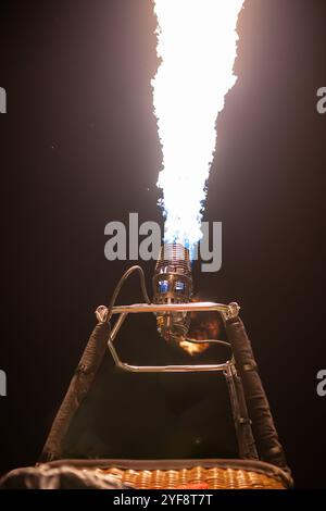 gros plan de la montgolfière montrant la flamme du brûleur qui brille une nuit Banque D'Images