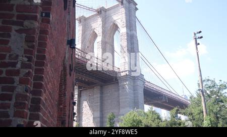 New York City Brooklyn Bridge depuis Dumbo. Mur de briques rouges, ancien entrepôt historique de tabac, marché et théâtre. Vue en angle bas. Arquez les fenêtres sous un monument emblématique. Voyage États-Unis, USA architecture Banque D'Images