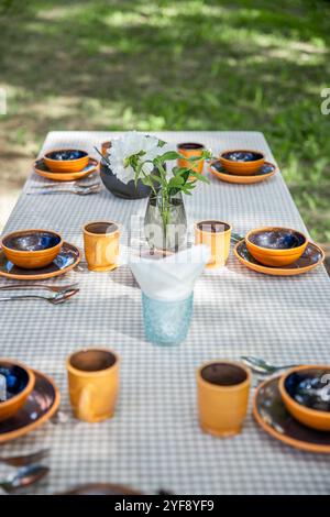 une table avec de belles faïences dans la cour sur une journée d'été ensoleillée Banque D'Images