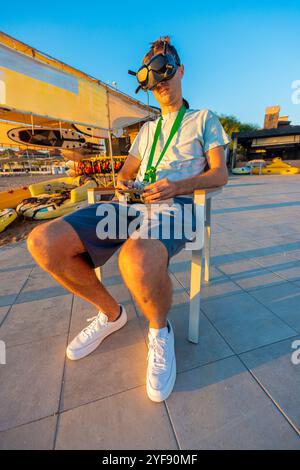 Pilote de drone FPV avec Goggles Controls Quadcopter sur Sunny Day by the Shore Banque D'Images