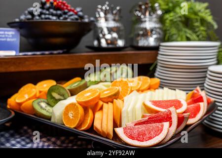 Assortiment de fruits frais affichage sur un buffet avec desserts et ustensiles, concept de restauration élégant dans l'hôtel Banque D'Images