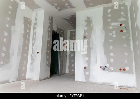 Intérieur d'une maison en cours de rénovation avec installation de cloisons sèches et application mixte Banque D'Images