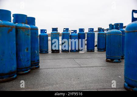 gamme de bouteilles de gaz propane bleu usagées alignées sur un sol en béton, fournitures essentielles pour les tâches de soudage industriel et de chauffage Banque D'Images