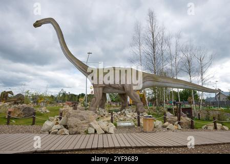 KIROV, RUSSIE - 30 AOÛT 2017 : sculpture dinosaure herbivore Mamenchisaurus nuageux par jour. Parc paléontologique pour enfants Banque D'Images