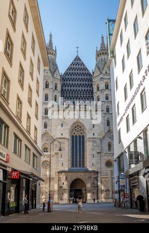 VIENNE, AUTRICHE - 8 AOÛT 2024 : la façade gothique de la cathédrale d'Étienne vue à travers une rue étroite dans le centre historique. Architecture d'église médiévale Banque D'Images