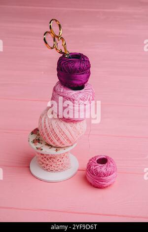 Un tas de fil coloré avec des ciseaux vintage collés dedans et ruban de dentelle parfait pour la couture, le tricot et d'autres loisirs créatifs, photo verticale. Banque D'Images