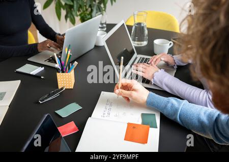 Vue sous un angle élevé des stratégies de planification des entrepreneurs masculins et féminins tout en travaillant au bureau Banque D'Images