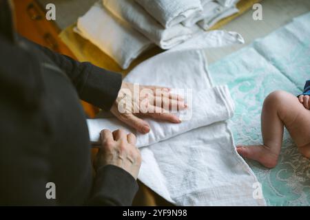 Vue à angle élevé de la femme âgée fabriquant une couche réutilisable pour bébé nouveau-né à la maison Banque D'Images