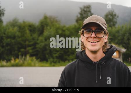 Portrait d'un jeune homme souriant par la route Banque D'Images