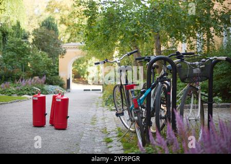 Vélos garés près des extincteurs sur le sentier dans le jardin Banque D'Images