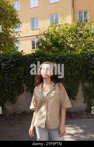 Portrait de belle jeune femme debout sur le sentier contre la construction Banque D'Images