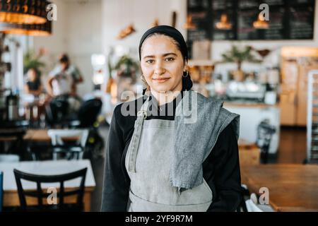 Portrait d'une serveuse debout dans un café Banque D'Images
