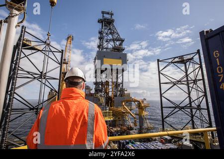 Ouvrier pétrolier sur un engin de forage à cric Banque D'Images