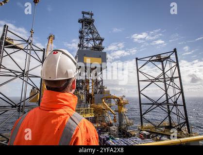 Ouvrier pétrolier sur un engin de forage à cric Banque D'Images