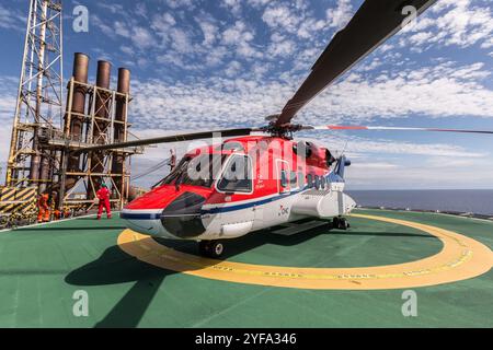 Hélicoptère sur l'héliport d'une plate-forme pétrolière offshore Banque D'Images