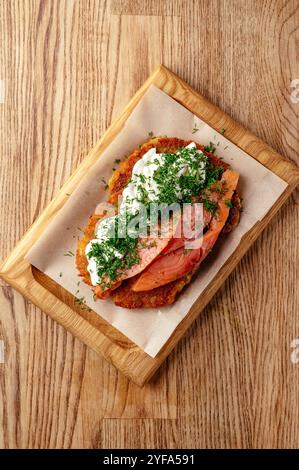 crêpes de pommes de terre avec du poisson rouge sur une assiette en bois Banque D'Images