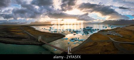 Vue aérienne de la lagune du glacier Jokulsarlon au coucher du soleil, avec de superbes icebergs bleus dans les eaux sereines de la destination emblématique de l'Islande. Banque D'Images