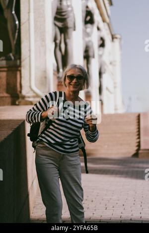 Une femme d'âge moyen voyage avec un sac à dos Banque D'Images