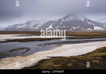 Paysage islandais avec lac gelé, montagnes et prairies couvertes de neige à la péninsule de snaefellsnes en Islande Banque D'Images