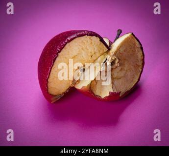 Pomme fraîche et tranche de fruits de pomme malsains pourris isolés sur fond magenta Banque D'Images