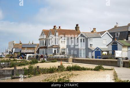 Whitstable, Royaume-Uni, 8 juin 2023 : touristes et habitants marchent le long du sentier de bord de mer avec des maisons britanniques traditionnelles à Whitstable kent Angleterre Banque D'Images