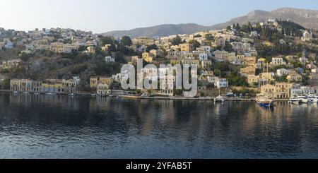 Symi, Grèce, 8 août 2016 : image panoramique de la ville et du port de Symi avec des maisons colorées sur la colline, une partie des îles grecques des Cyclades, dans l'Aege Banque D'Images