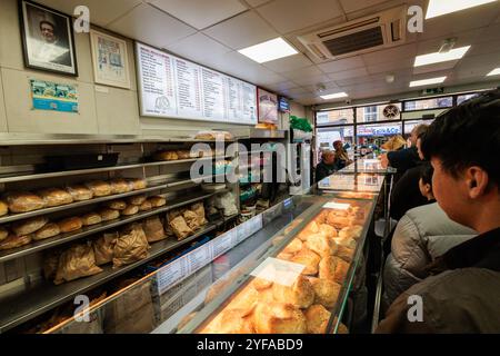 Londres, Royaume-Uni. 31 octobre 2024. Les clients font la queue dans la populaire boulangerie Beigel Bake à Brick Lane. Beigel Bake a été créé en 1974 et est ouvert 24h/24 et 7j/7. Son panneau blanc le distingue d'une boutique beigel voisine avec un panneau jaune connu des habitants comme 'le jaune'. Crédit : Mark Kerrison/Alamy Live News Banque D'Images