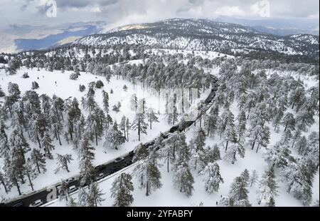 Paysage aérien de drone de route traversant le paysage enneigé de forêt de montagne en hiver.L'hiver Troodos montagnes Chypre Banque D'Images