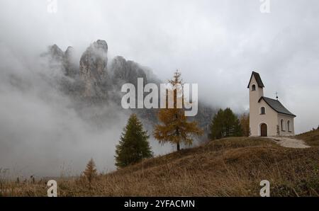 Église de cappella di san Maurizio Passo gardena col dans les Dolomites Tyrol du Sud Italie au début de l'automne avec du brouillard couvrant les montagnes de dolomie Banque D'Images