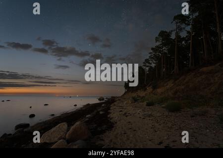 Scène nocturne en septembre, côte sablonneuse de l'île de Pedassaar, ciel étoilé, voie lactée et golfe de Finlande. Banque D'Images