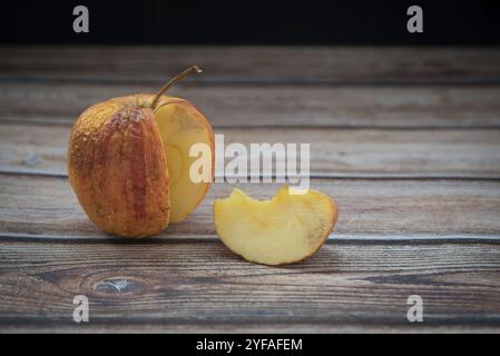 Pomme pourrie fanée rouge sur une table. Les bactéries ont infecté des fruits pourris Banque D'Images