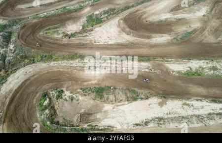 Drone aérienne d'une course de motocross sur une piste de sport de terre sinueuse. Vue aérienne des courses à grande vitesse Banque D'Images