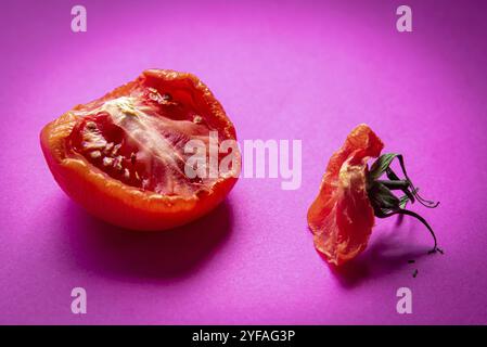 Tranche de légume de tomate rouge pourri unhealty isolé sur un fond magenta Banque D'Images