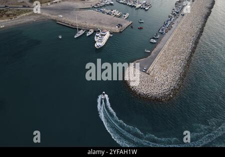 Vue aérienne de drone de hors-bord entrant dans le port yachts amarrés à la marina. Port de Latsi Paphos Chypre Banque D'Images