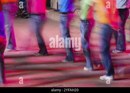 Groupe non reconnu de personnes dansant sur une scène. Blury mouvement des danseurs Banque D'Images