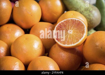 Tranche de fruits orange agrumes sur un tas d'oranges fraîches Banque D'Images