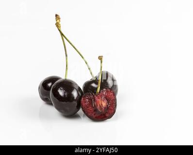 Fruits frais délicieux de cerise rouge juteux foncé isolé sur un fond blanc Banque D'Images