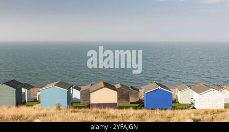 Cabanes de plage colorées de vacances en bois face à l'océan atlantique calme. Whitstable à Kent Grande-Bretagne Banque D'Images