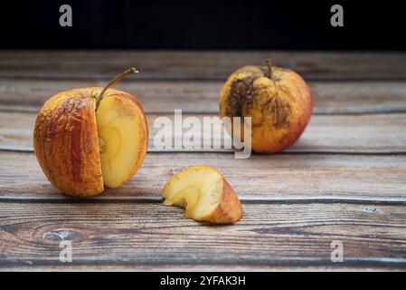 Pomme pourrie fanée rouge sur une table. Les bactéries ont infecté des fruits pourris Banque D'Images