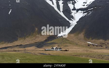 Paysage islandais typique avec des fermes sous la montagne couverte de neige en Islande. Centre sud-est de l'Islande Banque D'Images