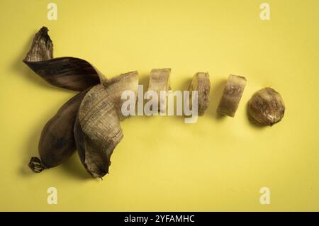 Tranches de banane pourrie malsaine sur fond jaune Banque D'Images