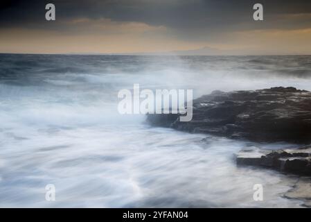 Bord de mer des Rocheuses avec océan ondulé et vagues qui s'écrasant sur les rochers. Photographie en exposition prolongée Banque D'Images