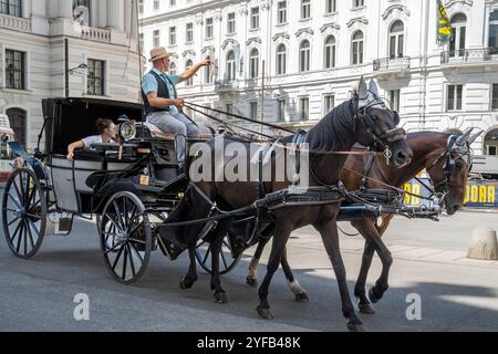 VIENNE, AUTRICHE - 12 AOÛT 2024 : calèche traditionnelle Fiaker avec carrosse près du palais de Hofburg dans le centre-ville historique Banque D'Images