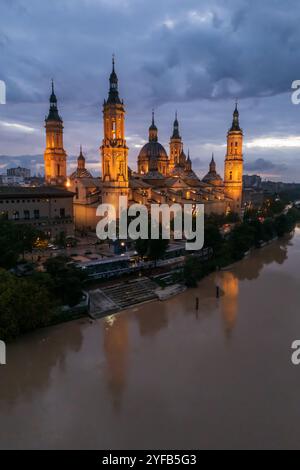 Vue aérienne d'une cathédrale basilique El Pilar illuminée et de l'Èbre la nuit, Saragosse, Espagne Banque D'Images